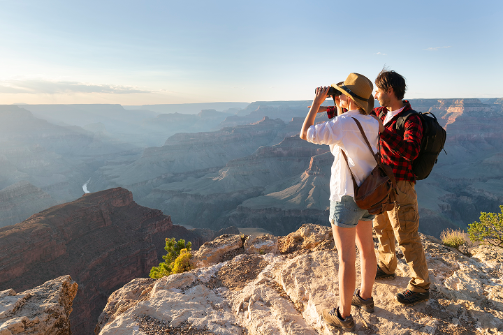 couple looking through binoculars in the arizona desert